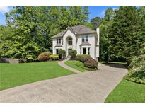 Charming two-story home featuring a well-manicured lawn and a welcoming driveway at 305 Jasmine Ct, Woodstock, GA 30189