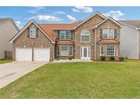 Beautiful brick and stone two-story home featuring an attached two-car garage and well-manicured lawn at 6637 Chason Woods Ct, Jonesboro, GA 30238