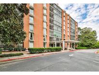 Brick building exterior featuring a covered entrance and manicured hedges and landscaping at 130 26Th St # 402, Atlanta, GA 30309