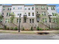 Beautiful three-story townhomes with brick and siding, landscaped with trees and greenery at 2505 Astaire Nw Ct, Atlanta, GA 30318