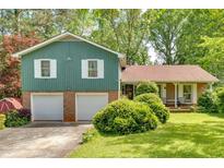 Charming home with a two-car garage, lush green lawn, and beautiful landscaping offering great curb appeal at 316 Shiloh Hills Nw Dr, Kennesaw, GA 30144
