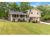 Charming two-story home with a brick chimney, red shutters, and manicured landscaping at 3781 Cherokee Trl, Suwanee, GA 30024