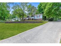 Charming split-level home with brick accents, mature trees, and a well-maintained lawn at 3116 Lakepoint Cir, Acworth, GA 30102