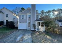 Charming two-story home featuring a covered front porch, attached garage and manicured lawn at 3210 Linden Dr, Lawrenceville, GA 30044
