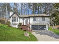 Charming home featuring two-car garage, wood deck and inviting curb appeal with mature trees at 5570 Deerfield Nw Pl, Kennesaw, GA 30144