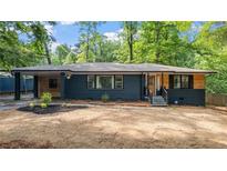 Charming one-story home featuring a brick facade, wood accents, a covered carport, and manicured landscaping at 715 Wood Valley Rd, Mableton, GA 30126