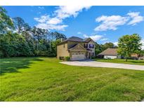 Charming two-story home featuring a two-car garage, manicured lawn, and mature trees at 2102 Braswell Ln, Loganville, GA 30052