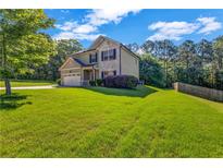 Beautifully kept lawn with mature trees surrounding the home at 2102 Braswell Ln, Loganville, GA 30052
