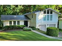 Charming two-story home with a well-manicured lawn, beautiful greenery, and a two car garage at 2804 Dunnington Cir, Chamblee, GA 30341