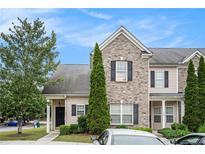 Attractive townhome exterior with brick accents, black shutters, and neat landscaping at 2555 Flat Shoals Rd # 801, Atlanta, GA 30349