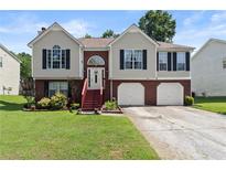 Charming two-story home with a well-maintained lawn and an inviting entrance and two-car garage at 4303 Anderson Ridge Dr, Austell, GA 30106