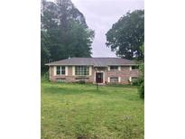 Charming brick ranch home with a well-manicured lawn and mature trees providing ample shade at 4961 Ivey Road, Acworth, GA 30101