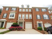 A brick townhouse featuring a one-car garage, trimmed windows, and well-maintained landscaping at 5587 Trace Views Dr, Norcross, GA 30071
