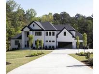 Beautiful modern home showcasing a white exterior, black trim, and spacious driveway at 3681 Hamilton Mill Rd, Buford, GA 30519