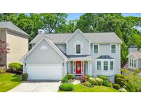 Charming two-story home featuring a red front door, manicured landscaping, and a two-car garage at 70 Parkside Cir, Marietta, GA 30068
