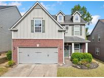 Charming two-story home featuring a brick facade, well-maintained lawn, and attached two-car garage at 121 Camdyn Cir, Woodstock, GA 30188