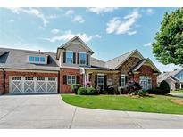 Charming two-story home featuring a brick and stone facade with a well-manicured lawn and attached two-car garage at 2771 Middlecreek Way, Cumming, GA 30041