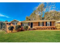 Charming brick home with a well-manicured lawn and classic curb appeal on a sunny day at 6575 Wendell Cir, Morrow, GA 30260