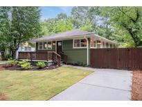 Charming home with a manicured lawn, inviting porch, and lush landscaping at 1142 Palafox Ne Dr, Atlanta, GA 30324