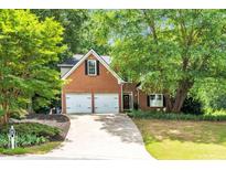 Charming two-story brick home with a well-manicured lawn and a two-car garage at 214 Kingsley Way, Woodstock, GA 30188