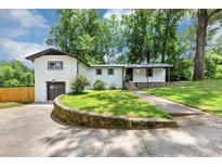 Charming white brick home with lush green lawn and driveway at 3807 Greenhill Dr, Chamblee, GA 30341