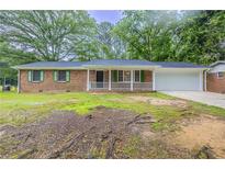 Charming brick ranch home featuring a front porch and well-manicured landscaping at 5964 W Fayetteville Rd, Atlanta, GA 30349