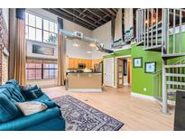 Bright and airy living room featuring a modern kitchen, spiral staircase, and large windows with natural light at 791 Wylie Se St # 410, Atlanta, GA 30316