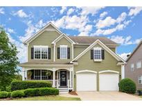 Charming two-story home featuring a welcoming porch, two-car garage, and well-maintained landscaping at 216 Toonigh Way, Canton, GA 30115