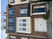 Brick townhouse featuring a two-car garage and a blue front door, and double hung windows with blue shutters at 2928 George Busbee Pkwy, Kennesaw, GA 30144