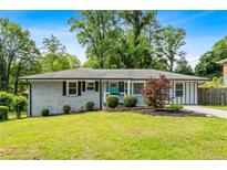 Charming ranch-style house with a manicured front yard and a light blue front door at 3153 Bonway Dr, Decatur, GA 30032