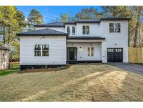 Inviting modern home with a black roof, white siding, and manicured lawn at 3444 Underwood Se Ct, Conyers, GA 30013