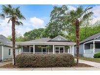 Charming home featuring a welcoming porch, complemented by lush landscaping and mature palm trees at 206 Flora Ne Ave, Atlanta, GA 30307
