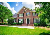 Stately brick home with black shutters and lush green lawn and mature trees at 213 Shady Valley Dr, Carrollton, GA 30116