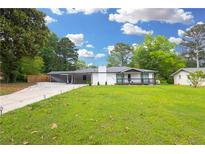 Charming renovated home with a well-manicured front yard and a covered carport offering convenient parking at 4166 Idlevale Dr, Tucker, GA 30084