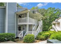 Inviting two-story condo with dual balconies, surrounded by lush greenery and freshly landscaped yard at 2748 Suwanee Se Way, Marietta, GA 30067