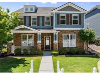 Charming two-story home with stone and blue siding, manicured lawn, and inviting entrance at 3524 Old Towne Ln, Cumming, GA 30040