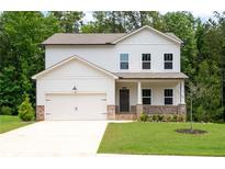 Charming two-story home with a well-manicured lawn and a welcoming front porch and attached two car garage at 63 Brookstone E Park, Acworth, GA 30101