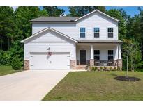 Charming two-story home featuring stone accents, a covered porch, and an attached two-car garage at 63 Brookstone E Park, Acworth, GA 30101