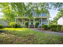 Charming two-story home featuring a welcoming front porch and well-manicured landscaping at 1491 Kolb Ridge Sw Dr, Marietta, GA 30008