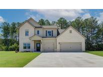 Two-story home with brick accents, a spacious driveway, and an attached two-car garage at 211 Linford Dr, Locust Grove, GA 30248