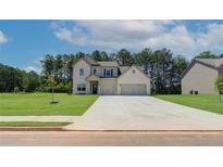 Charming two-story home with a light brick exterior, two-car garage and well-manicured lawn on a sunny day at 211 Linford Dr, Locust Grove, GA 30248