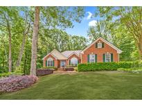 Charming brick home featuring a manicured lawn, lush landscaping, and a welcoming entrance at 2333 Orion Ct, Grayson, GA 30017