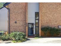 Charming brick townhome with a black front door and decorative wreath at 3268 Clairmont Ne, Brookhaven, GA 30329