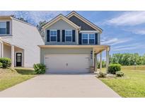 Charming two-story home featuring a two-car garage, well-maintained lawn, and inviting covered porch area at 5567 Union Pointe Pl, Union City, GA 30291