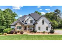 Stunning two-story home with a stone facade, lush landscaping, and a welcoming front porch at 104 Meadow View Trl, Canton, GA 30115