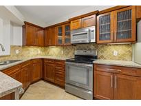 This kitchen features wooden cabinetry, stainless steel appliances, and beautiful granite countertops at 3334 Peachtree Ne Rd # 101, Atlanta, GA 30326