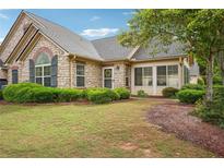 Charming stone home with a well-manicured lawn and lush landscaping at 401 Kenley Ct, Mcdonough, GA 30253