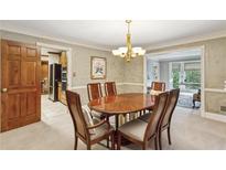Elegant dining room with wood table, six chairs, chandelier, and open access to the kitchen and living areas at 3298 Robinson Oaks Ne Way, Marietta, GA 30062