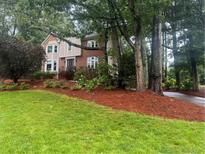 Charming brick home with a well-manicured lawn and mature trees, showcasing curb appeal at 3298 Robinson Oaks Ne Way, Marietta, GA 30062
