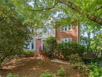 Charming two-story brick home featuring lush landscaping and a welcoming entrance, nestled among mature trees at 3298 Robinson Oaks Ne Way, Marietta, GA 30062